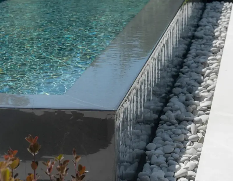 Modern Minimalist Pool Design with Sleek Black Concrete Waterfall