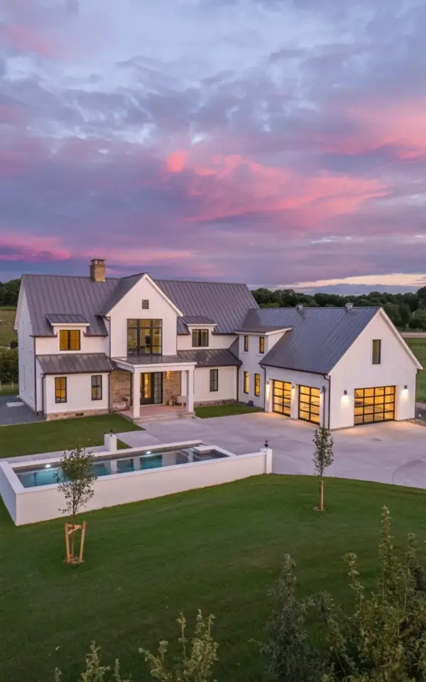 Modern Farmhouse Mansion at Sunset with Pool and Stone Pillars | Luxury Home Exterior