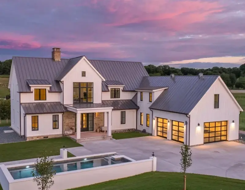 Modern Farmhouse Mansion at Sunset with Pool and Stone Pillars | Luxury Home Exterior