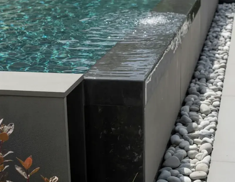 Modern Minimalist Pool Design with Black Concrete Water Feature